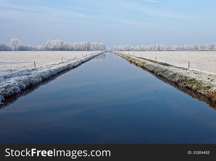 Canal in a cold white winter landscape