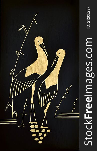 A wooden picture of a stork couple. A wooden picture of a stork couple