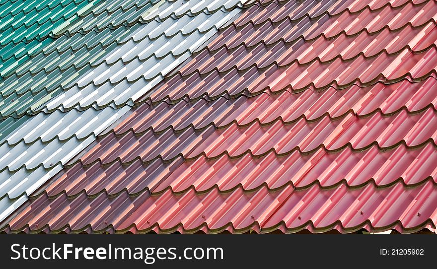 Different colourful stripes of tiled roof on a new roof. Different colourful stripes of tiled roof on a new roof