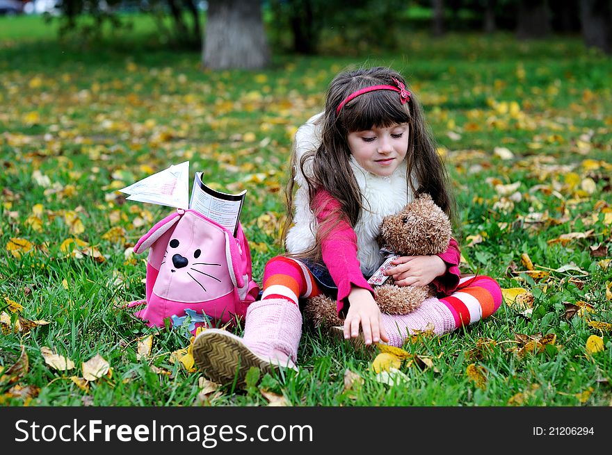 Cute little girl wearing fur coat in autumn forest