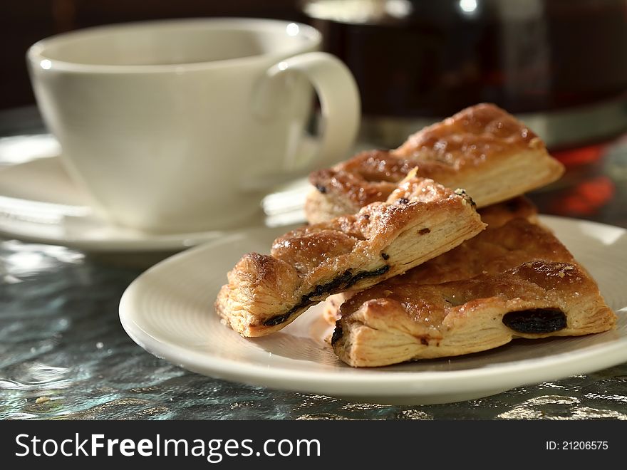 Raisin pie biscuits served with tea on the background in a dramatic afternoon light. Raisin pie biscuits served with tea on the background in a dramatic afternoon light.