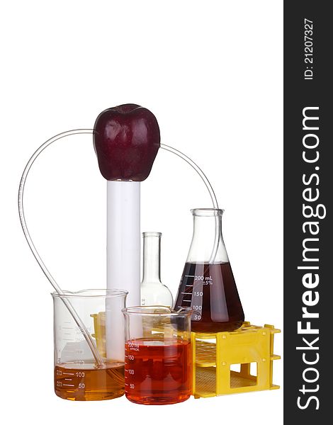 Red apple with transparent tubes leading to scientific beakers and flasks on a white background. Red apple with transparent tubes leading to scientific beakers and flasks on a white background.