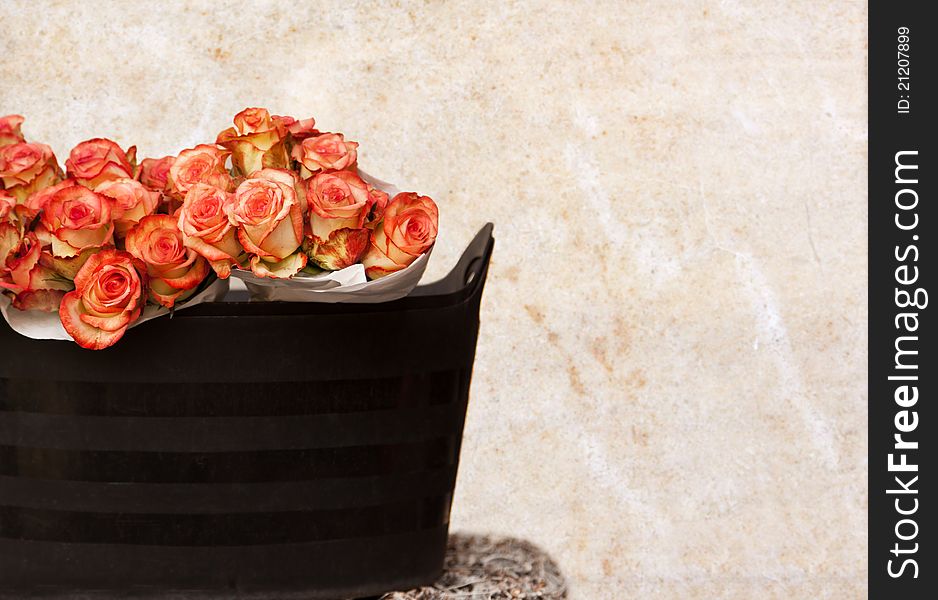 Roses Bouquets in Basket and Polished Marble Wall Background.