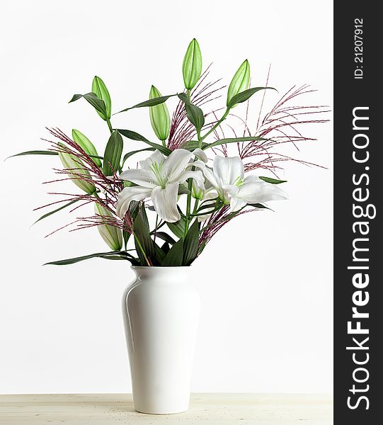 Bouquet of white lilies in a white vase on white Background. Bouquet of white lilies in a white vase on white Background