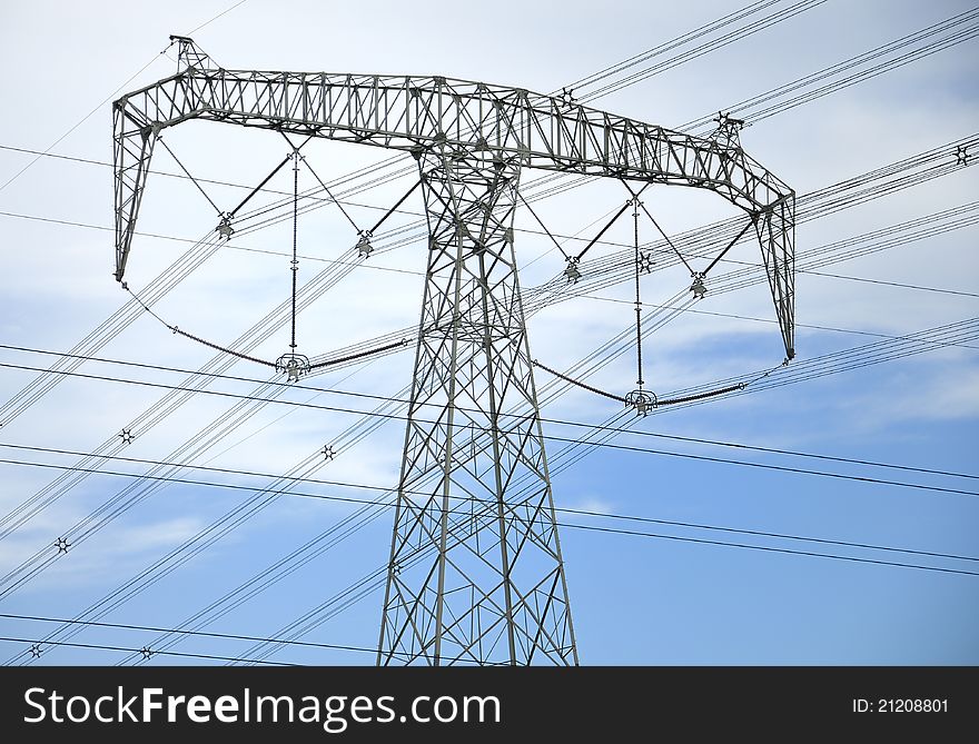 High-tension line and transformer over white cloud.