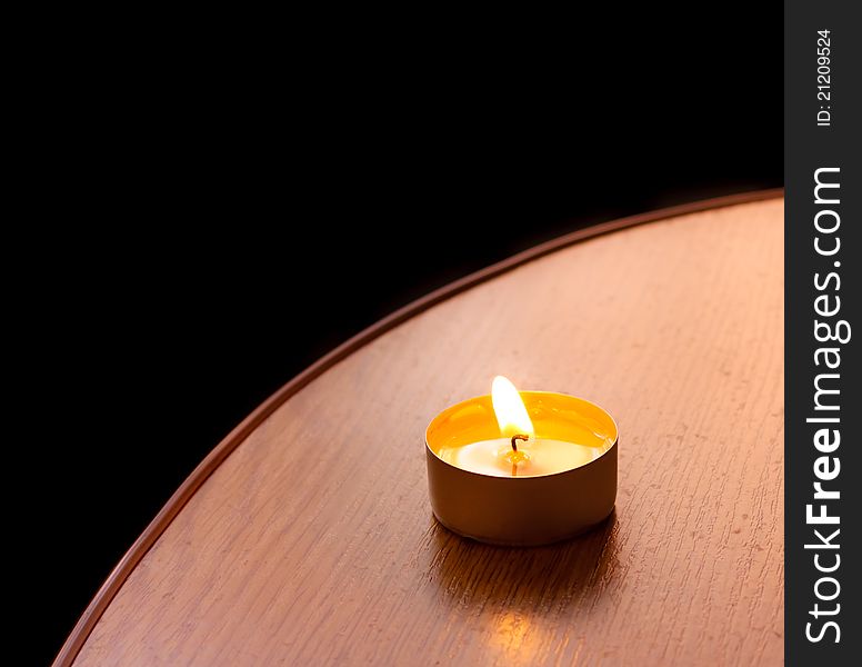 Closeup of burning candle on table