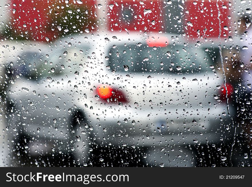 Photo of cars in the rain across the windshield. Photo of cars in the rain across the windshield.
