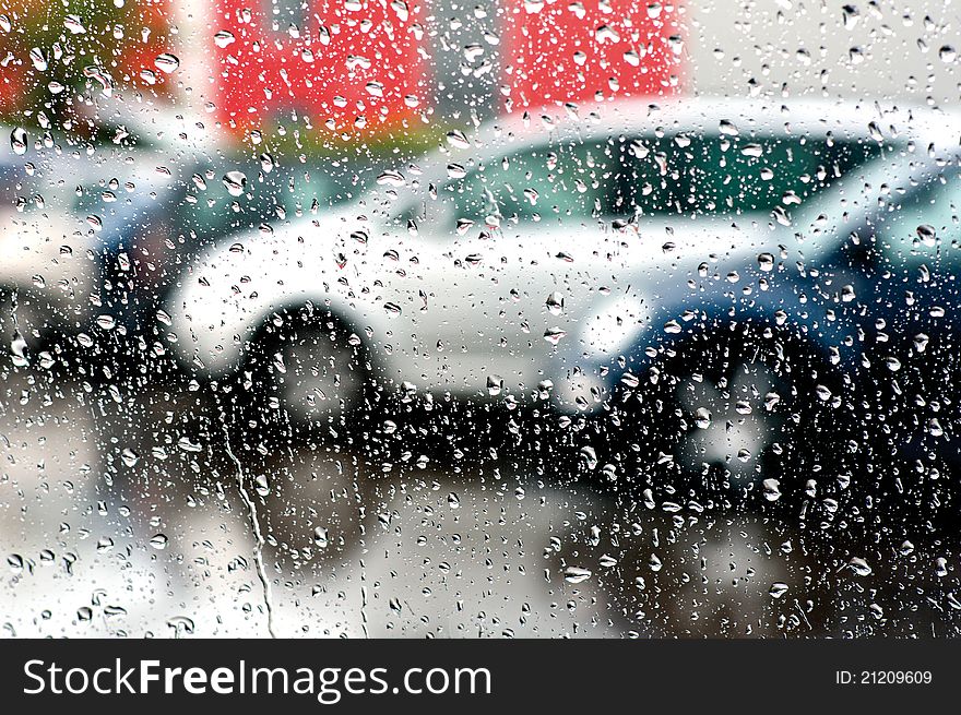 Photo of cars in the rain across the windshield. Photo of cars in the rain across the windshield.