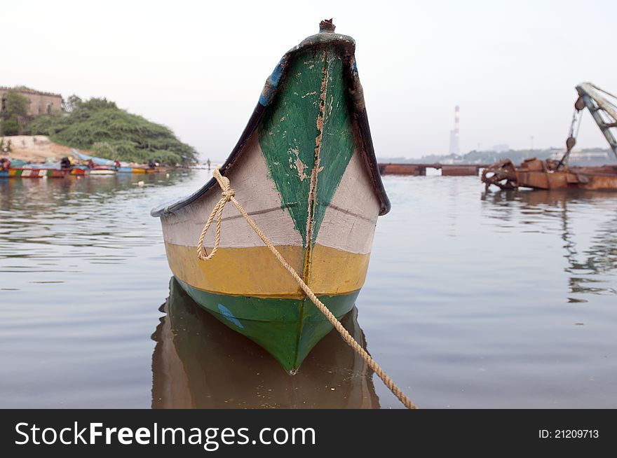 An old deserted boat tied to the pier at a local fishing harbor