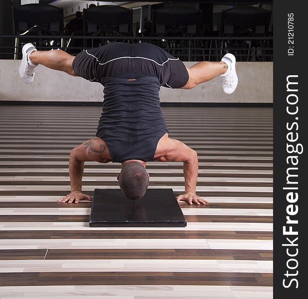 Fitness instructor doing stand on his head