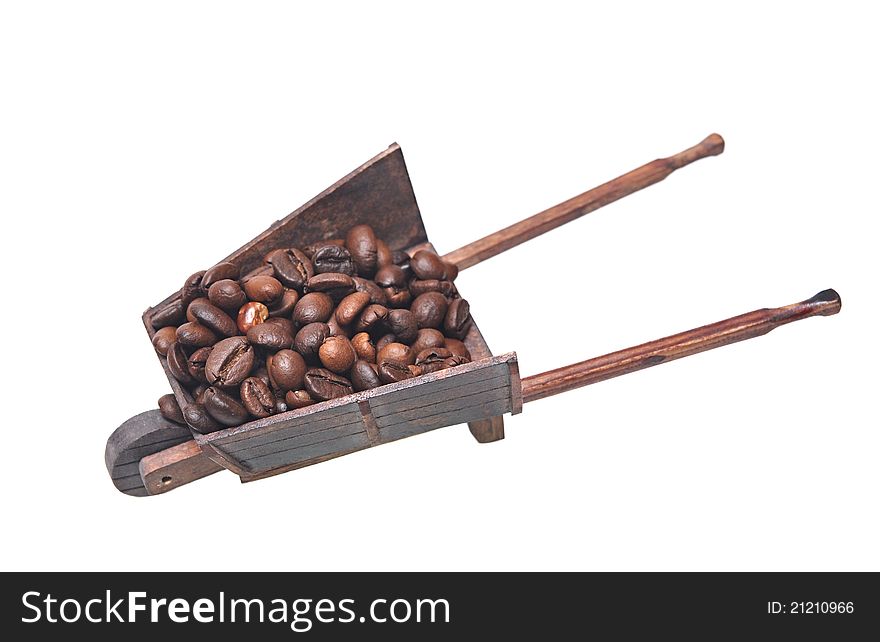 Miniature model of the wheelbarrow with filled coffee beans on white