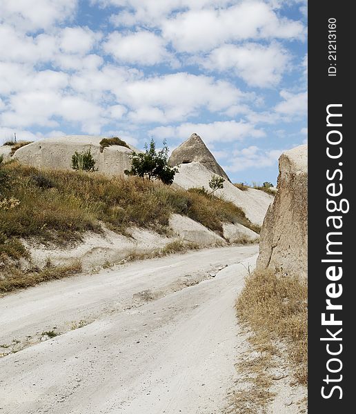 Dirt track in the wilderness of Cappadocia Turkey, blue cloudy sky, portrait, crop space and copy area. Dirt track in the wilderness of Cappadocia Turkey, blue cloudy sky, portrait, crop space and copy area