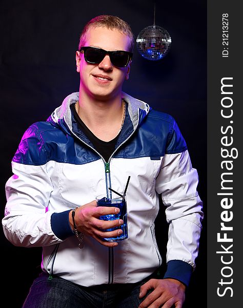 Young stylish guy with a blue cocktail in the nightclub. Young stylish guy with a blue cocktail in the nightclub