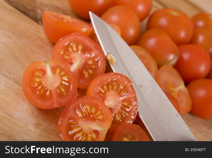 Sliced Cherry tomatoes on a wooden chopping board