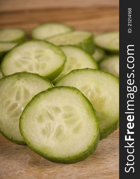 Sliced continental cucumber on a wooden chopping board