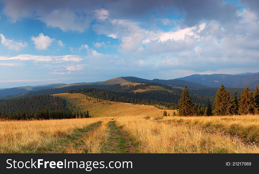 Summer landscape in mountains with the cloudy sky