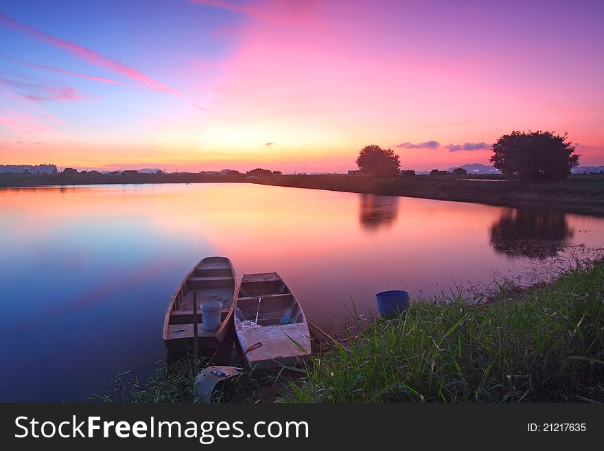 Sunset Along The Pond With Isolated Boats