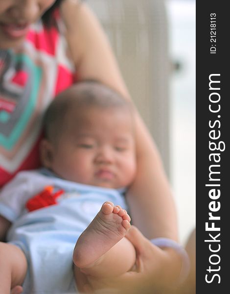 A baby lying in mother's arm with his foot close-up. A baby lying in mother's arm with his foot close-up