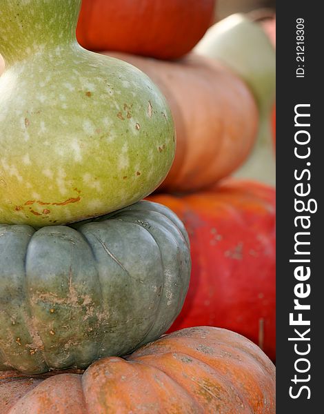 Different types of pumpkins stacked one over the other