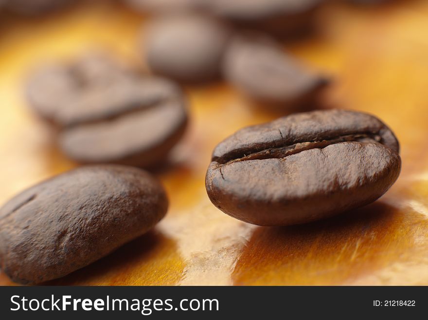 Coffee beans on wooden table close up