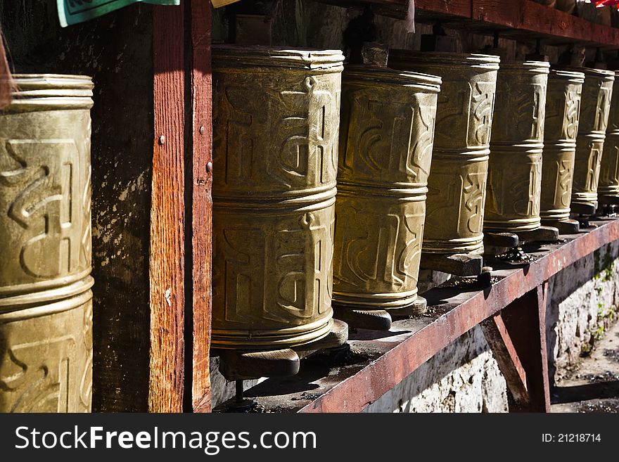 Tibetan prayer wheels at the gate of a monastery in tibet.
