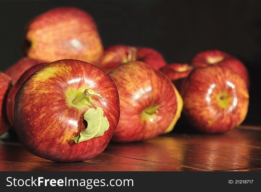 Beautiful shiny red apples placed on a table on a dark background. Beautiful shiny red apples placed on a table on a dark background