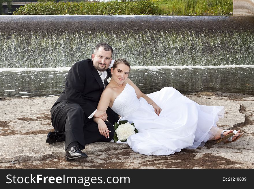 Wedding couple posing by the waterfall. Wedding couple posing by the waterfall