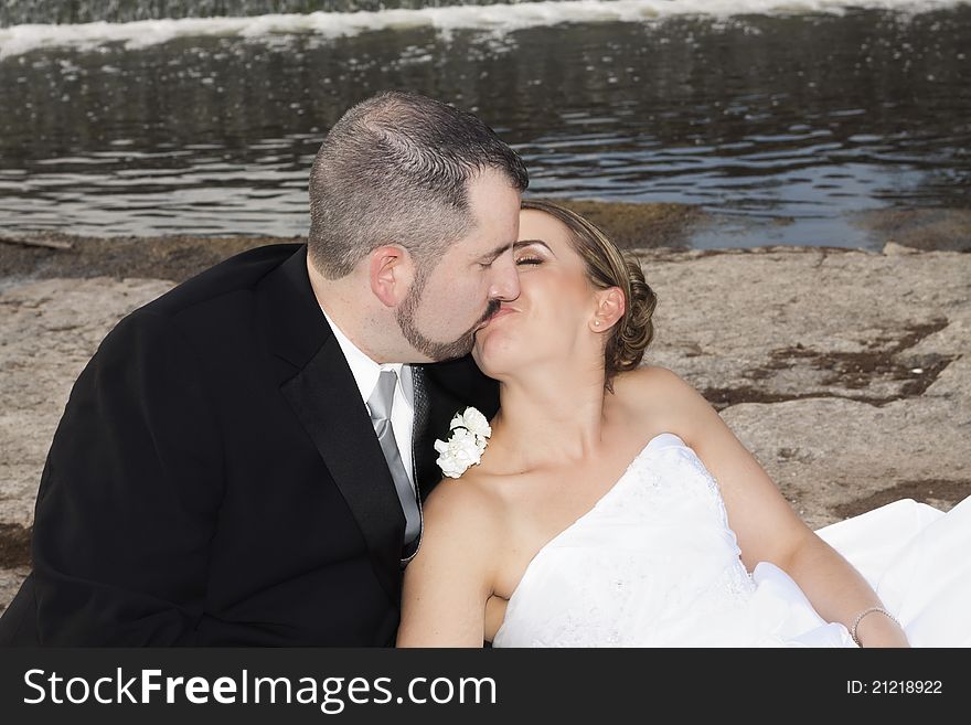 Wedding couple kissing by the waterfall. Wedding couple kissing by the waterfall