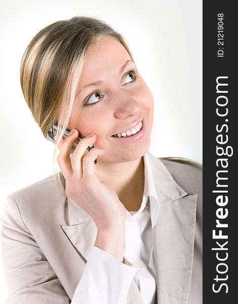 Blonde business woman in beige suit jacket talking on cell phone. Blonde business woman in beige suit jacket talking on cell phone