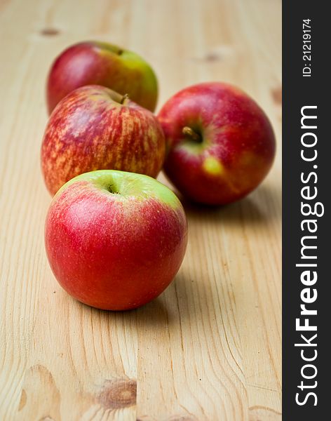 Red ripen apples on wooden table close up