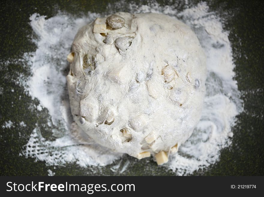 Artichoke cheese bread dough on a cutting board with flour