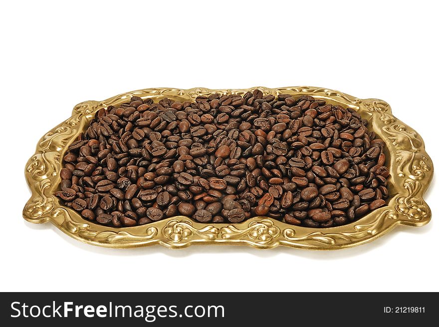 Grains of roasted coffee on a tray on a white background