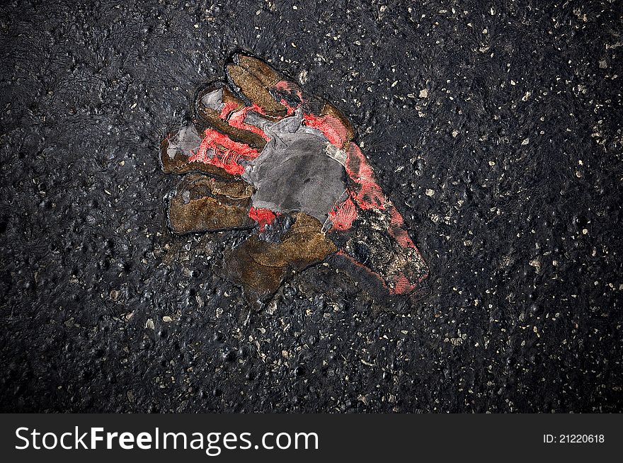 A shabby, frayed glove melted into the asphalt. A shabby, frayed glove melted into the asphalt
