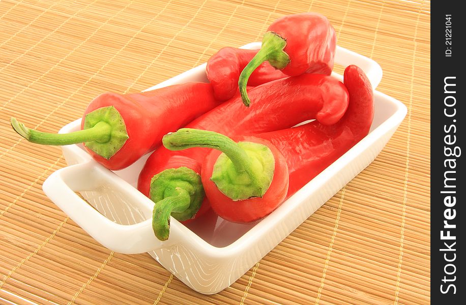 Four hot red peppers on plate