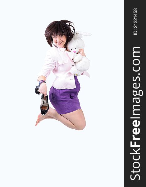Young beautiful woman jumping in joy with plush rabbit and black shoes in her arm, isolated over a white background. Young beautiful woman jumping in joy with plush rabbit and black shoes in her arm, isolated over a white background