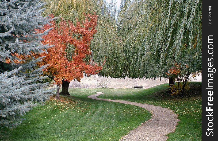 Winding park path to Boise River overlook through manicured lawn and early autumn foliage. Winding park path to Boise River overlook through manicured lawn and early autumn foliage