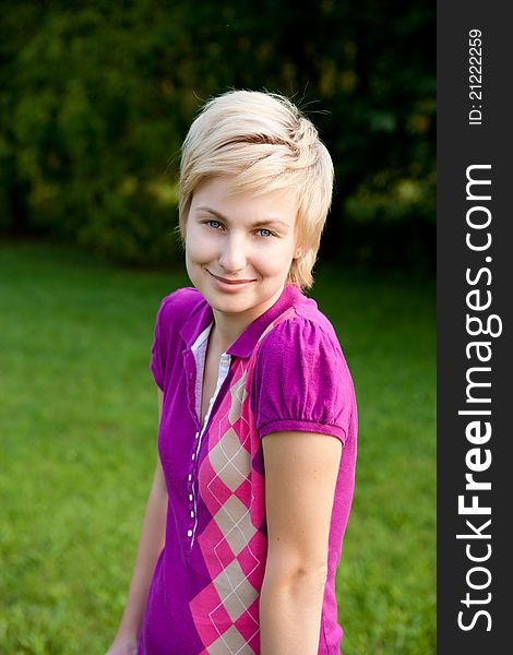 Closeup portrait of young smiling woman outdoors in the park