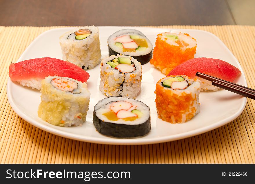 Different kinds of sushi on a plate (focus on middle one)