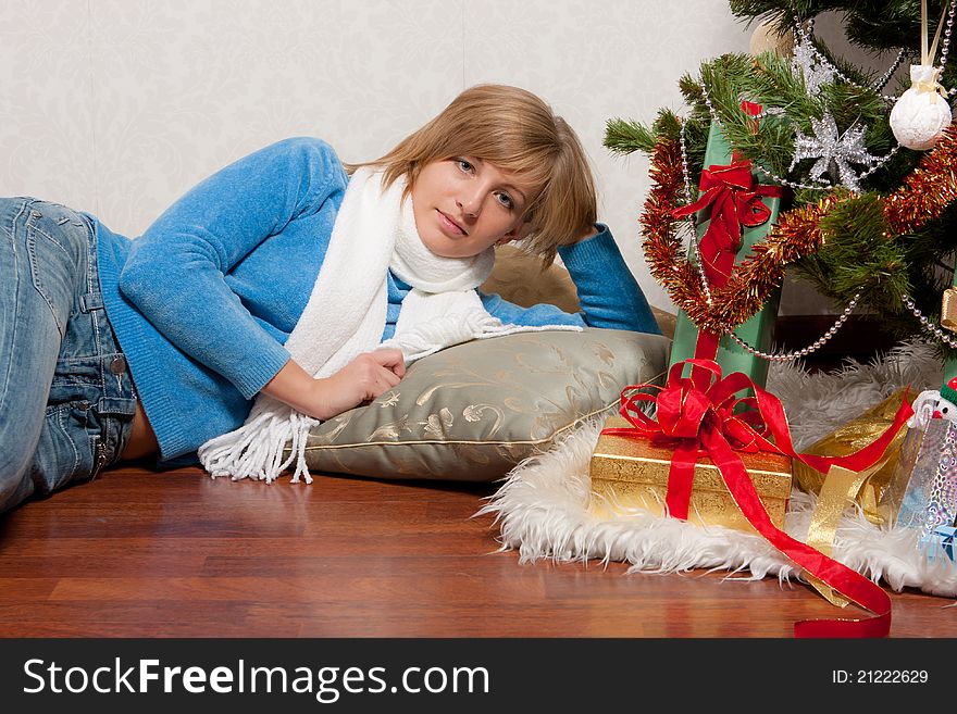 A young woman lies near a new-year tree. A young woman lies near a new-year tree