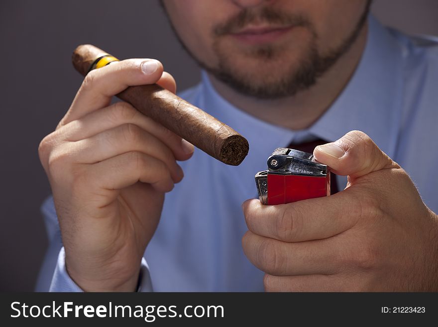 Man in the blue shirt holding a cigar. Man in the blue shirt holding a cigar