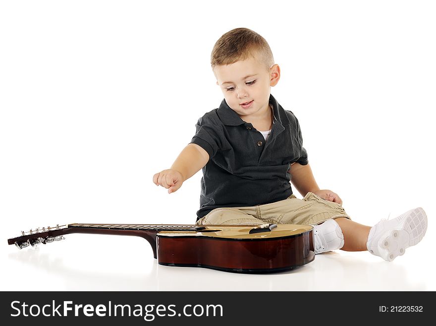 An adorable toddler happily plucking the strings of a small guitar. Isolated on white. An adorable toddler happily plucking the strings of a small guitar. Isolated on white.