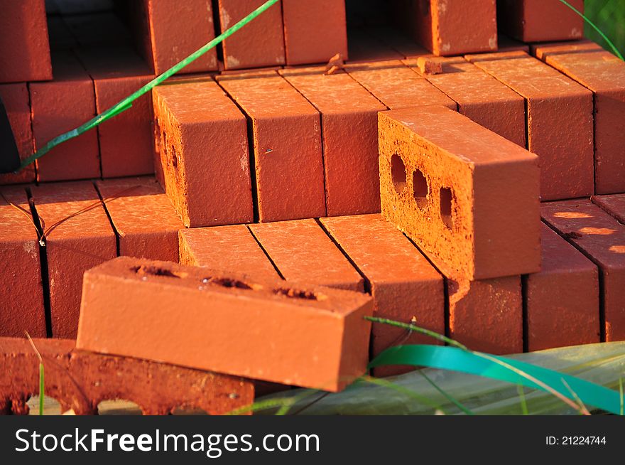 Stack of three hole red bricks.