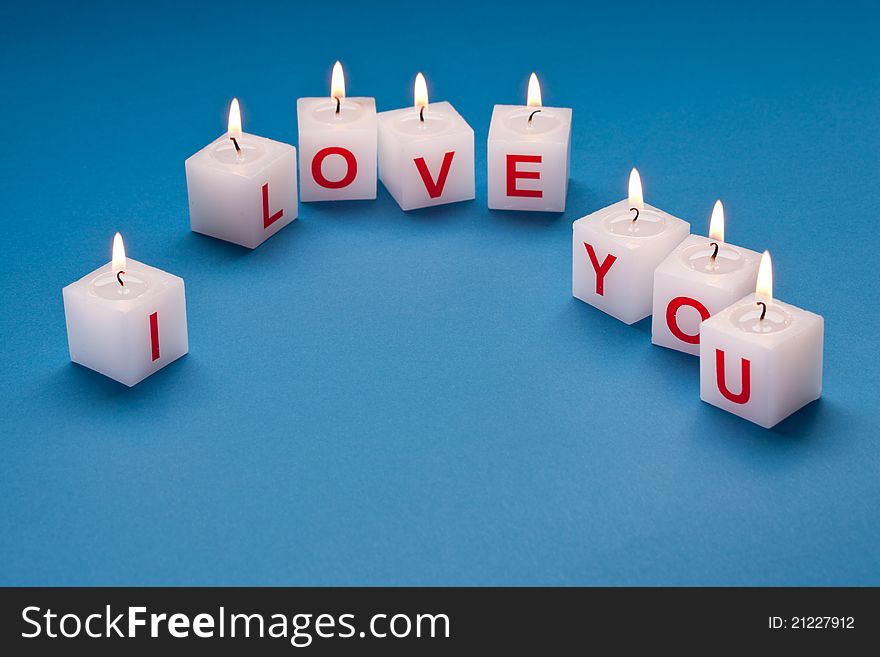 I love you printed on candles on a blue background. I love you printed on candles on a blue background