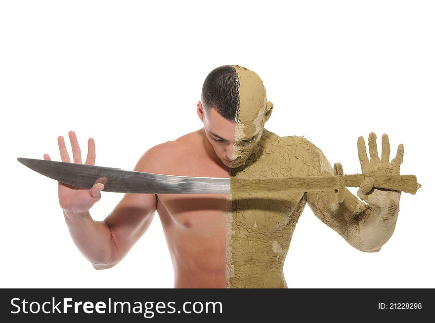 Young man half smeared with clay with sword