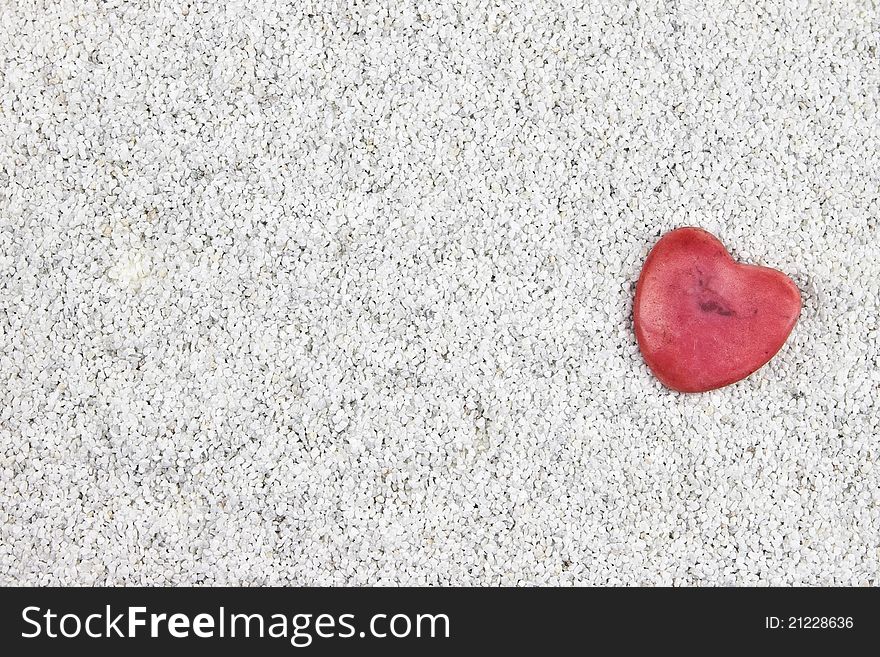 A read heart in white sand. A read heart in white sand