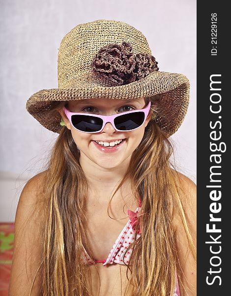 Eight year old girl with hat, sunglasses and beach towel. Eight year old girl with hat, sunglasses and beach towel