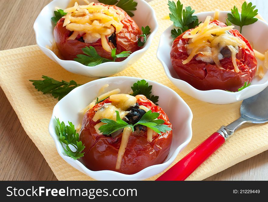Baked stuffed tomatoes in white saucers