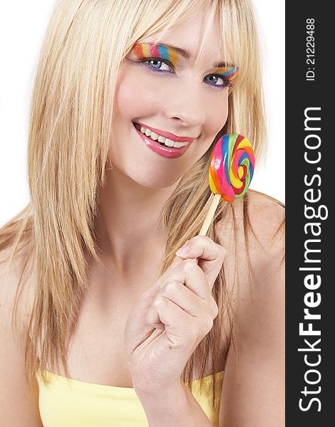 Beautiful blonde woman with colorful eye make-up holding a lollipop