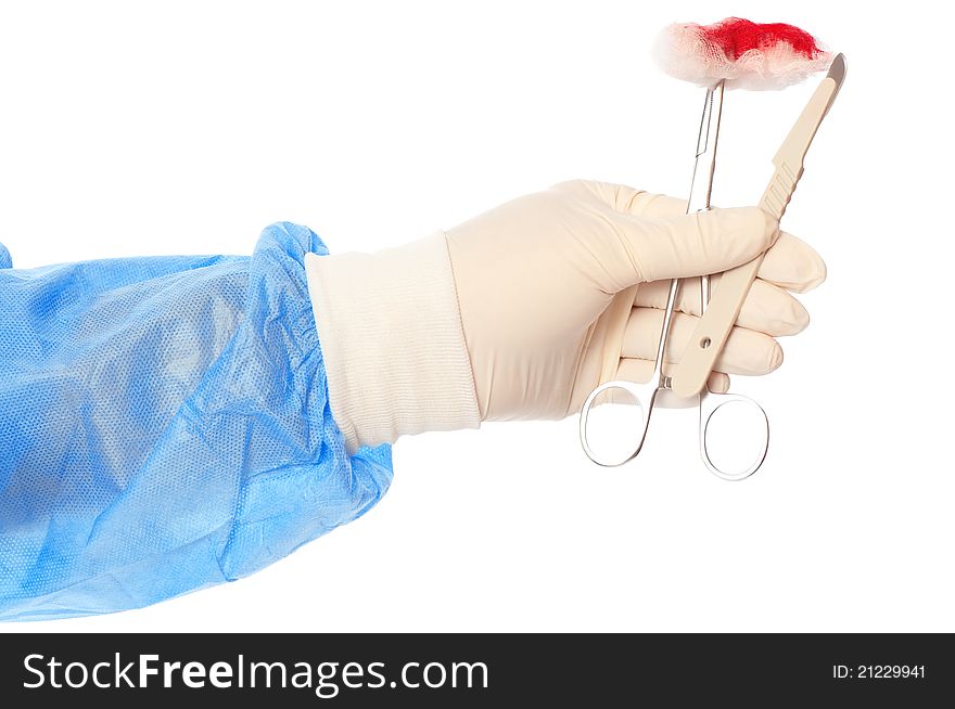 Scalpel and clamp with swab in the hand of the surgeon during a surgery. Scalpel and clamp with swab in the hand of the surgeon during a surgery