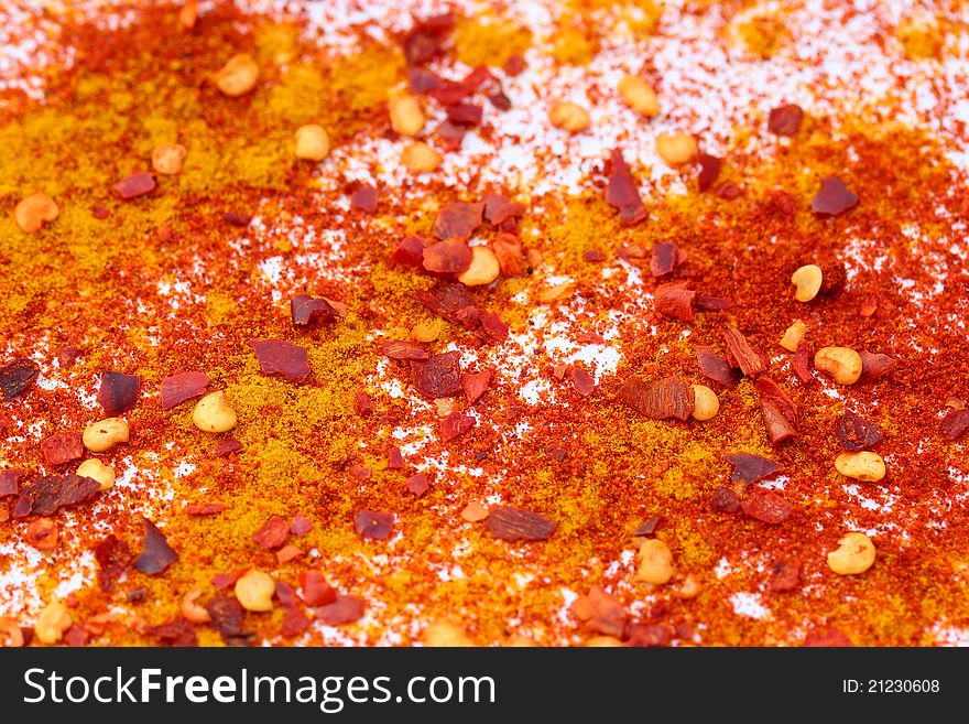 Background made of curcuma, sweet paprika and chili flakes. Bright colors on white background. Background made of curcuma, sweet paprika and chili flakes. Bright colors on white background.